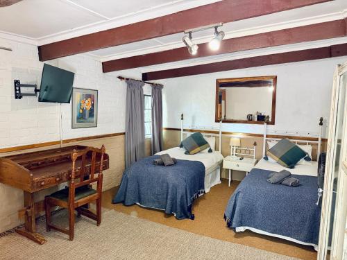 a bedroom with two beds and a piano at Mizpah Lodge in Bloemfontein