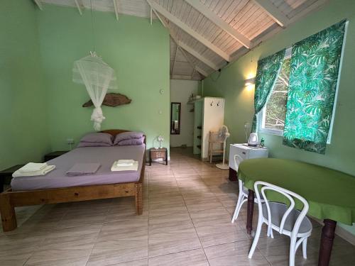 une chambre avec un lit, une table et des chaises dans l'établissement Soufriere Guesthouse, à Soufrière