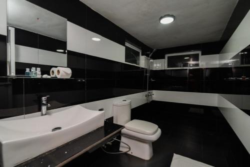 a bathroom with a white toilet and a sink at Anaya Villa in Nuwara Eliya