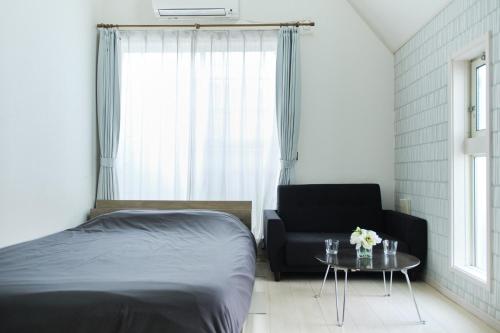 a bedroom with a bed and a chair and a table at Etoile Soshigaya / Vacation STAY 62643 in Kamatachō