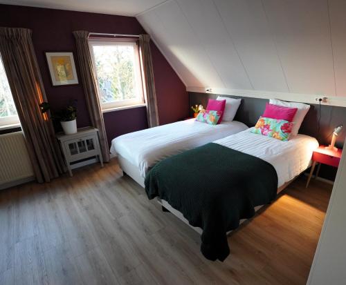 a bedroom with two beds and two windows at De Sas in Lisse in Lisse
