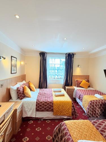 a bedroom with two beds and a window at Albro House Hotel, London in London
