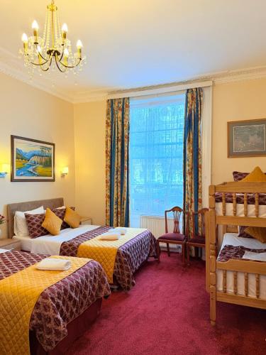 a hotel room with two beds and a window at Albro House Hotel, London in London