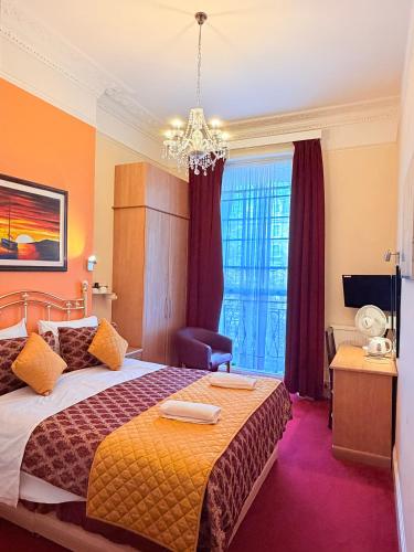 a hotel room with a bed and a chandelier at Albro House Hotel, London in London