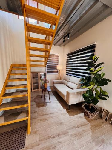 a living room with a staircase and a couch at Who's Gloria in El Nido
