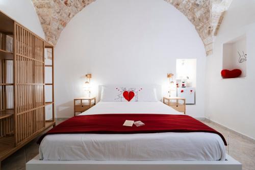 a bedroom with a bed with a red heart on it at Filo Rosso in Ostuni