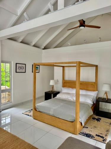 a bedroom with a wooden canopy bed in a room at Tabu in La Digue