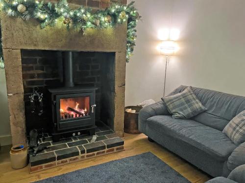 a living room with a fireplace and a couch at Vine Cottages in Crich