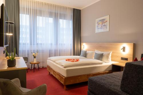 a hotel room with a bed and a large window at Best Western Comfort Business Hotel Düsseldorf-Neuss in Neuss
