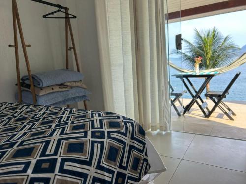 a bedroom with a bed and a view of the ocean at Angra dos reis Serra e Mar in Angra dos Reis
