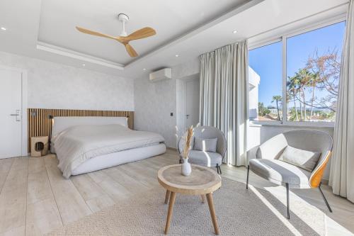 a bedroom with a bed and a table and chairs at Stunning 5-Bed Villa with Private Pool in Manilva