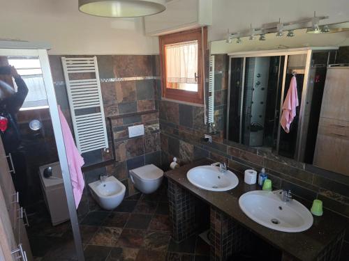 a bathroom with two sinks and two toilets at Casa Castellina in Bettolle