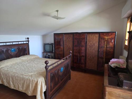 a bedroom with a large wooden bed and a tv at Casa Castellina in Bettolle