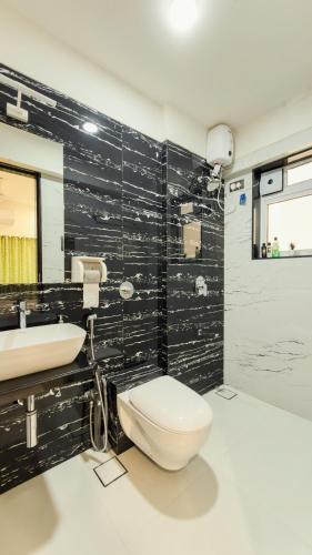a bathroom with a toilet and a sink at CozyKey Kalina in Mumbai