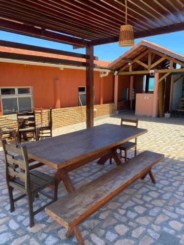 a wooden picnic table and benches on a patio at Hospedagem Terral Beach Canoa Quebrada in Aracati