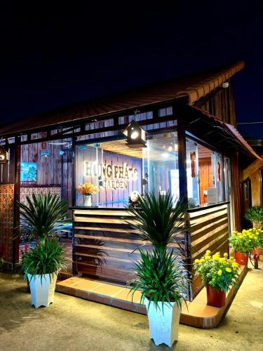 a store front with potted plants in front of it at Hưng Phát Hotel 2 - Gadren in Phú Lợi