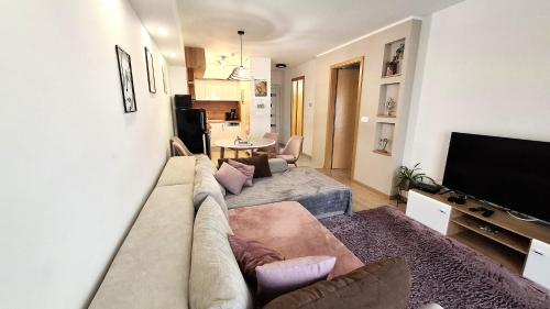 a living room with a couch and a television at Riella Home in Szombathely