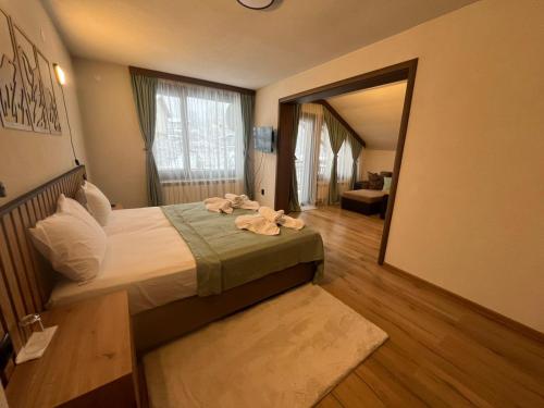 a bedroom with a bed with towels on it at Guest House Raffe in Dobrinishte