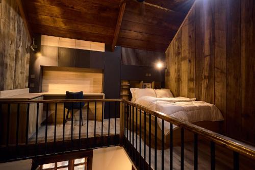 un balcone con un letto in una stanza con pareti in legno di Premier Cabins a North Legon