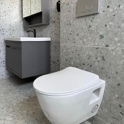 a bathroom with a white toilet and a sink at Houefa home résidence in Cotonou