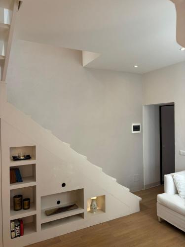a white living room with a white couch and stairs at Luxury Apartment in Moltrasio Center in Moltrasio