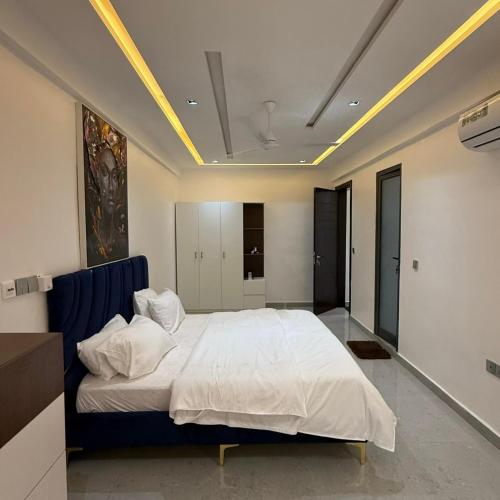 a bedroom with a large white bed with a blue headboard at Houefa home résidence in Cotonou