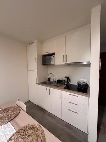 a kitchen with white cabinets and a sink and a microwave at Studio in Leuven in Leuven