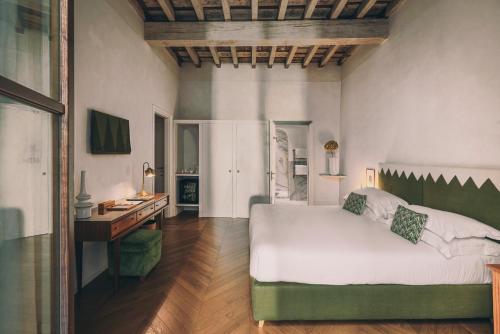 a bedroom with a large white bed and a desk at Casa G. Firenze in Florence