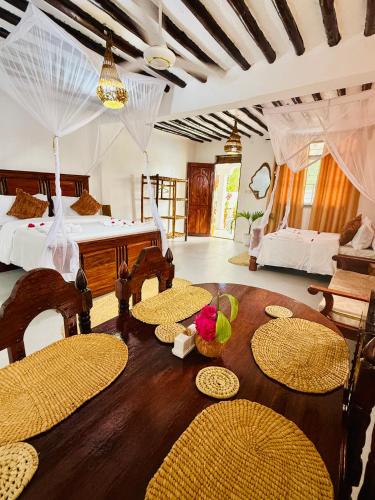 a bedroom with a bed and a table and chairs at Peace and Love Villa in Jambiani