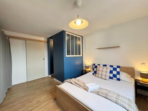 a bedroom with a bed and a blue wall at Chez Jacob, Centre de Rennes in Rennes