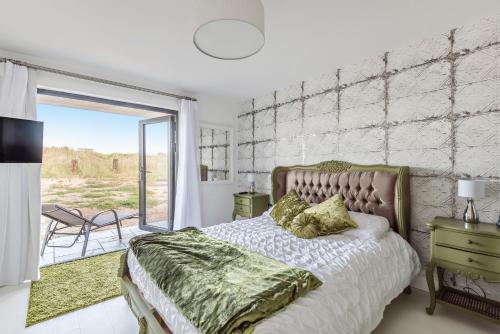 a bedroom with a bed and a large window at Washington Beach House in Heacham