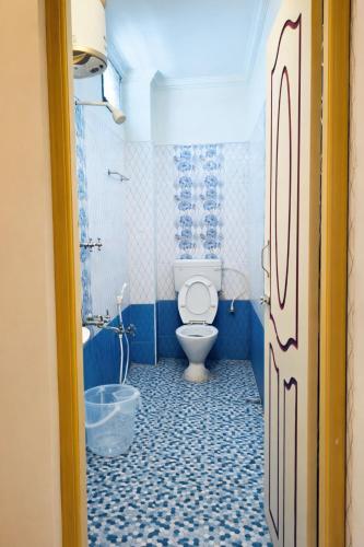 a blue bathroom with a toilet and a tub at MG Elite Residency in Pondicherry