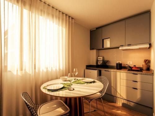 a small kitchen with a table and chairs in a room at Easy Life Campus PUC by Xtay - Estúdio completo próximo PUCPR in Curitiba