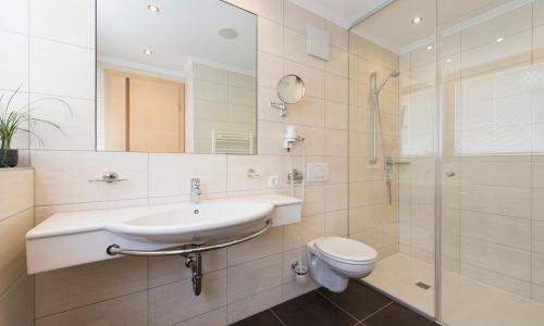 a bathroom with a sink and a toilet and a shower at Hotel Abendrot by Alpeffect Hotels in Ischgl