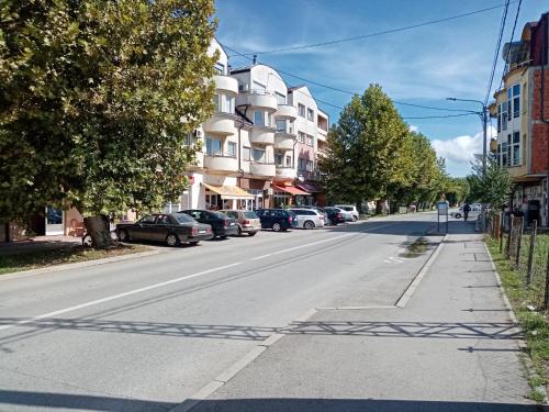 an empty street with cars parked on the side of the road at Sava & Double Rooms in Prijedor