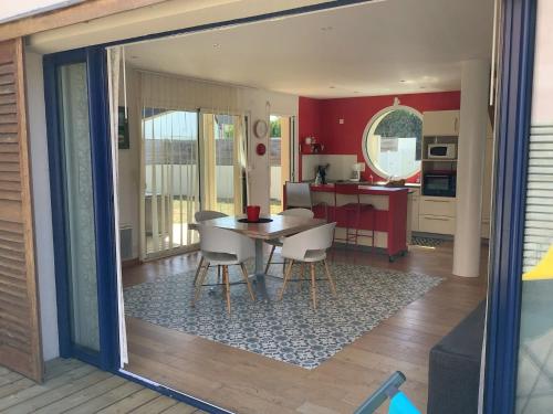 Maison SPA et PLAGE في سارزو: غرفة طعام ومطبخ مع طاولة وكراسي