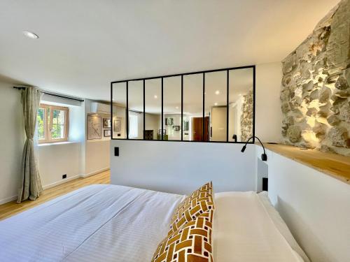 a bedroom with a bed and a stone wall at Mont Pellat - Spacieux studio au Charme Unique in Bassens