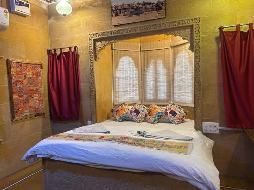 a bedroom with a large bed with red curtains at Hotel Pol Haveli Jaisalmer in Jaisalmer
