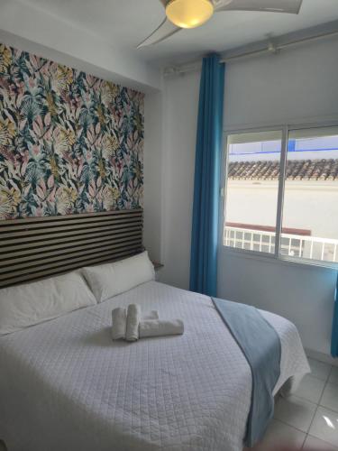 a bedroom with a bed with a towel on it at Bajondillo Beach Apartment By Torremolinos On-line in Torremolinos