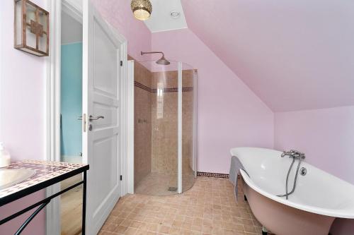 a bathroom with a bath tub and a shower at Villa Ferie og Overnatning in Svendborg