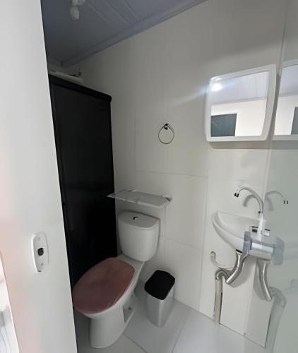 a bathroom with a toilet and a sink at Studio luxo Periperi in Salvador