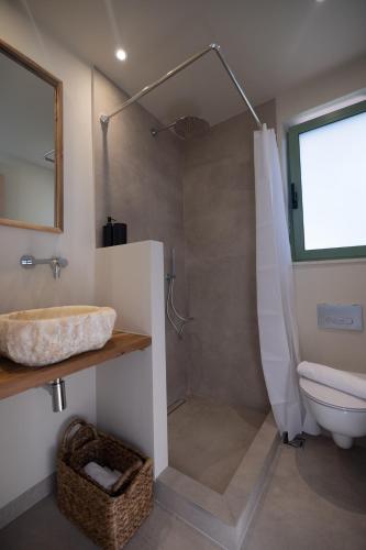 a bathroom with a shower and a sink and a toilet at Ionian Nest Studio in Pogoniá