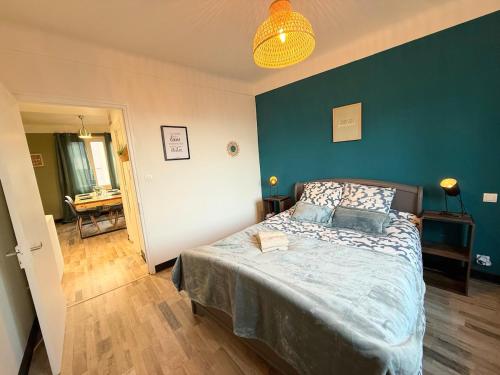 a bedroom with a bed with a blue wall at Appartement, centre, cozy in Rodez