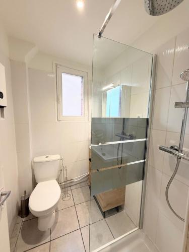 a bathroom with a toilet and a glass shower at Appartement, centre, cozy in Rodez