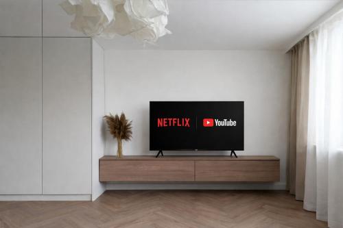 a flat screen tv sitting on a stand in a living room at Apartament pod Ratuszem - Kluczbork in Kluczbork