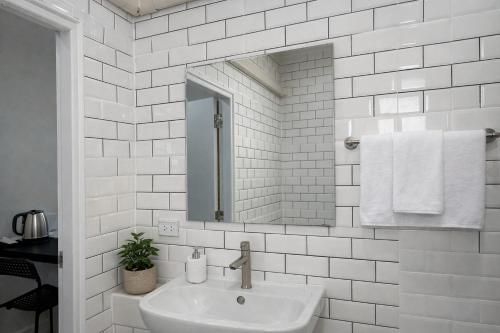 a white bathroom with a sink and a mirror at The 9 Motel in Ngao