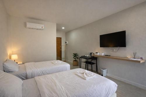 a hotel room with two beds and a flat screen tv at The 9 Motel in Ngao