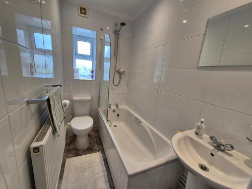 a white bathroom with a toilet and a sink at Tommy Two-Threes in Pill