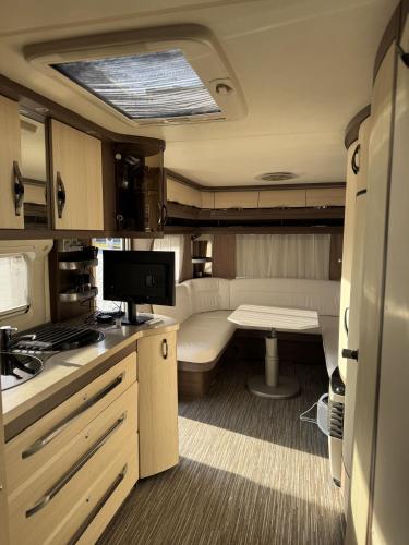 a small kitchen with a table and a tv in it at Camping Bansko "Between the Mountains" in Bansko