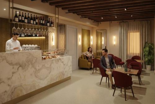 three people sitting at a bar in a restaurant at Hotel San Samuele in Venice
